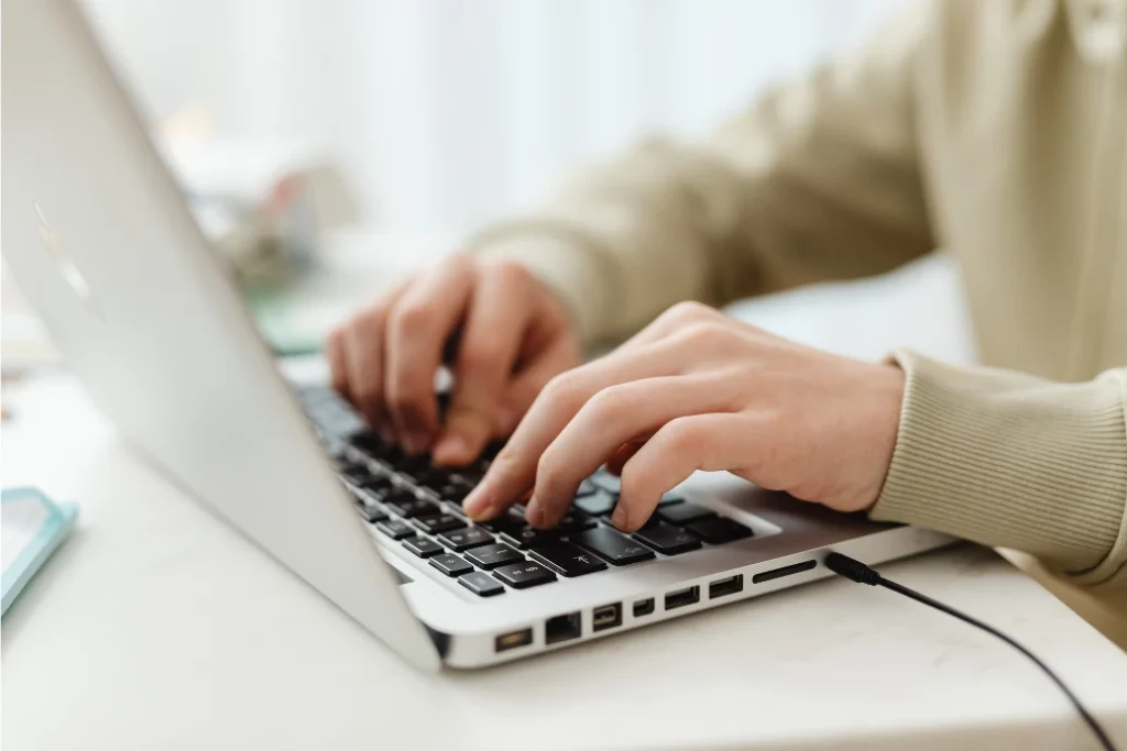 manos de persona trabajando con una laptop